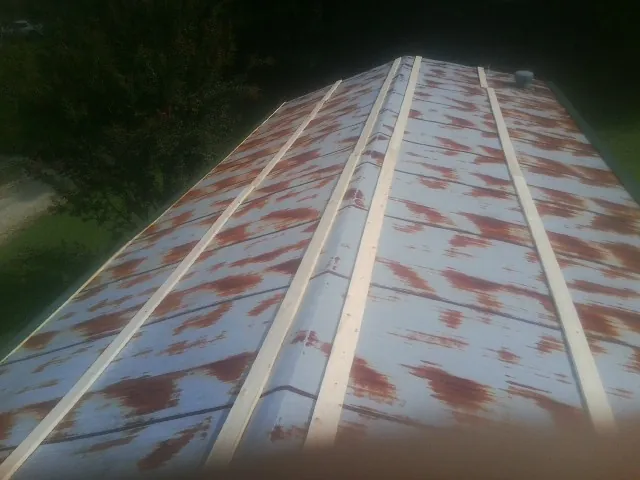 Rusted metal roof panels with new wood purlins before replacement — Storm Damage Roof Repair in Colfax by Roofing Brothers